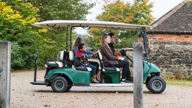 Image shows family seated on a buggy at Calke Abbey